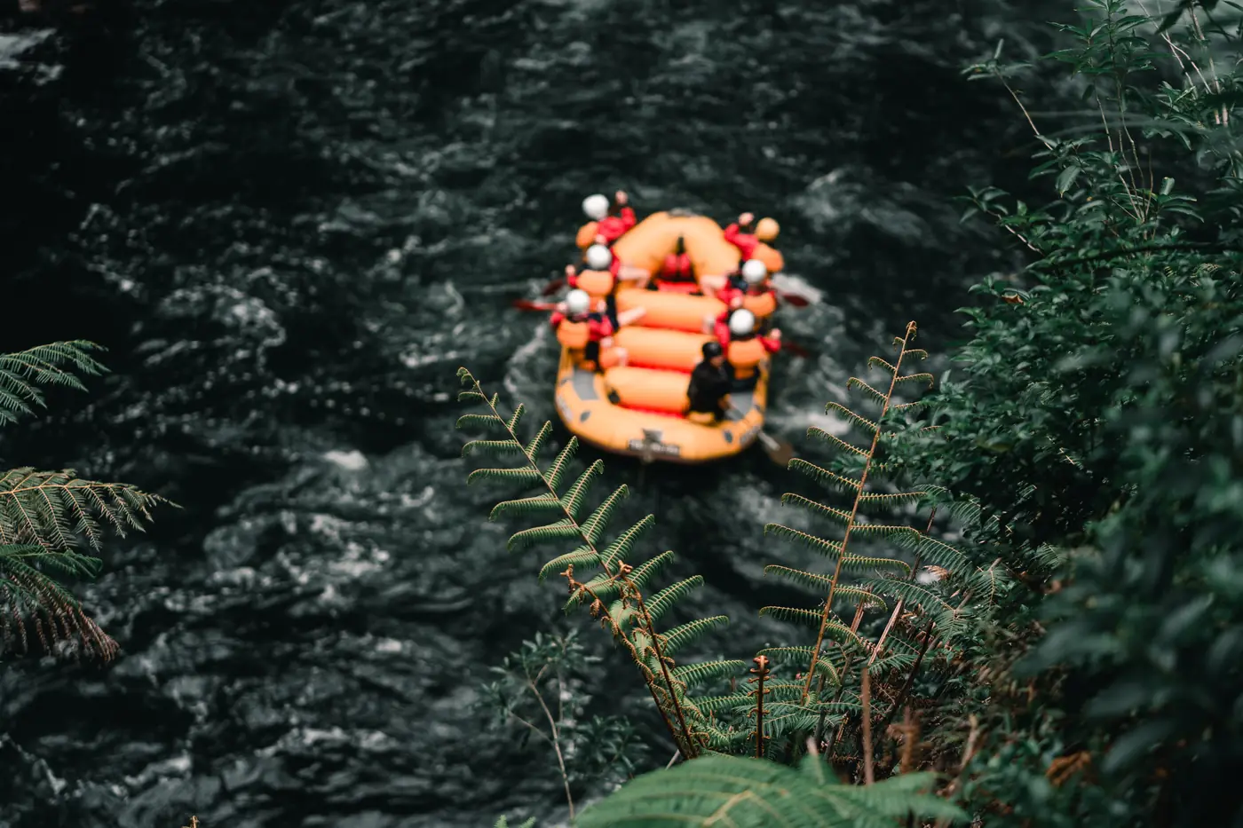 A raft seen from above on a dark green river